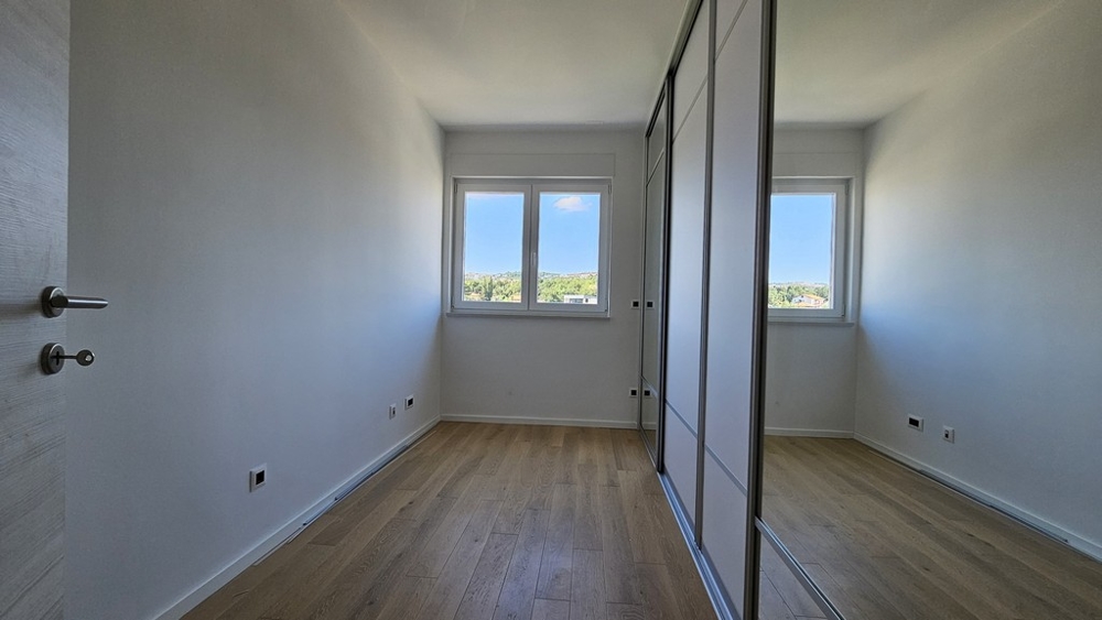 Prázdna izba s drevenou podlahou a vstavanými skriňami