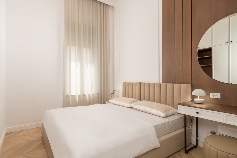 Spálňa s béžovou posteľou a písacím stolom