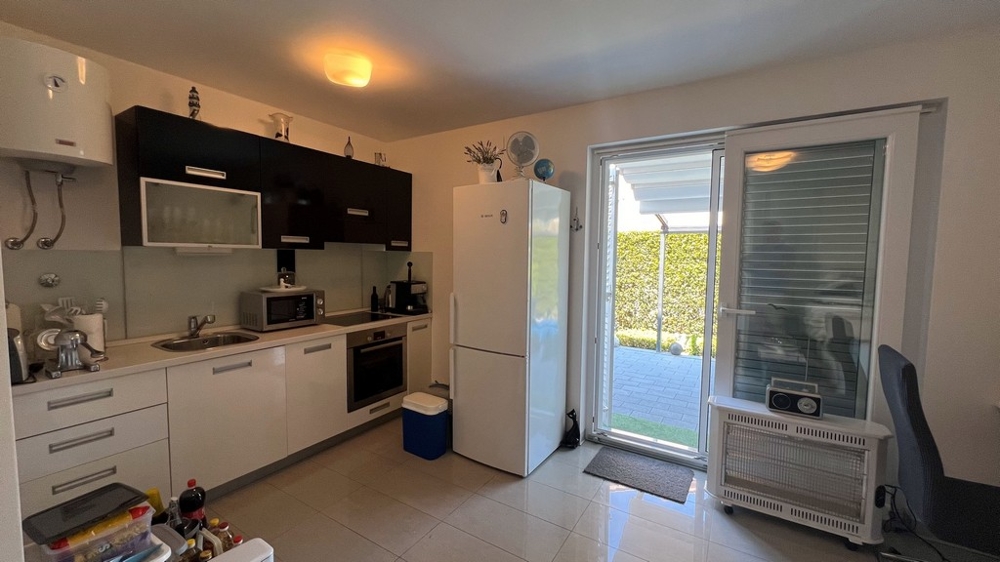 Kuchynská časť garsónky na prízemí s priamym vstupom do záhrady.