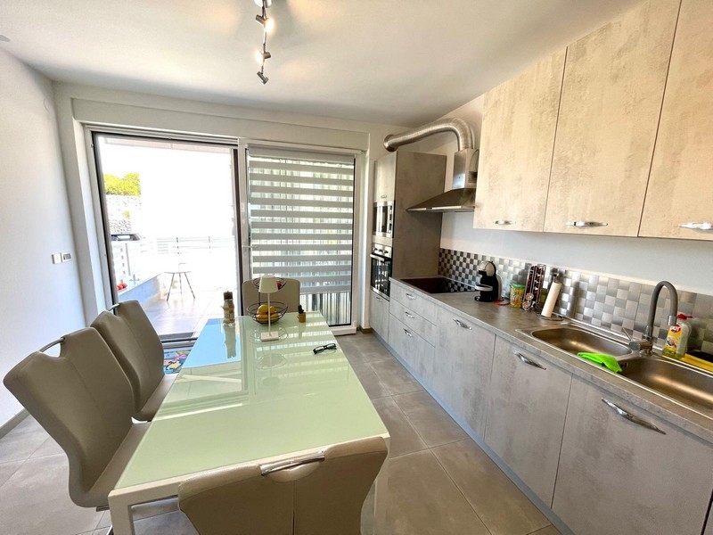 Jedálenský kút a moderná kuchyňa apartmánu A3387, ktorý je na predaj v Krku.