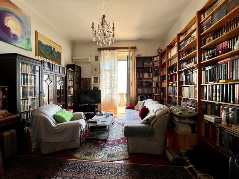 Byt s veľkými a vysokými policami na knihy.