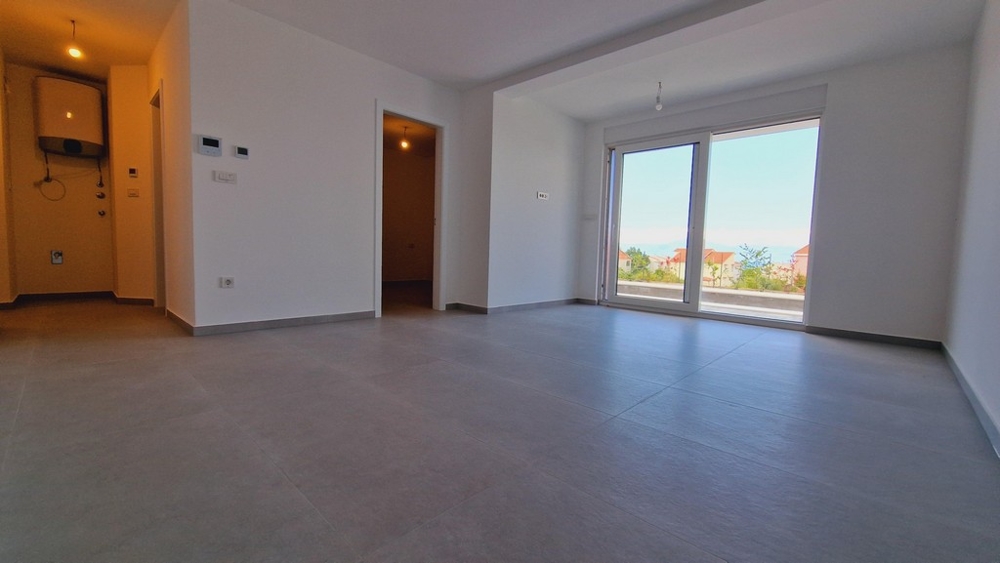 Moderný interiér bytu s veľkými oknami, výhľadom do záhrady a vstupom do izieb