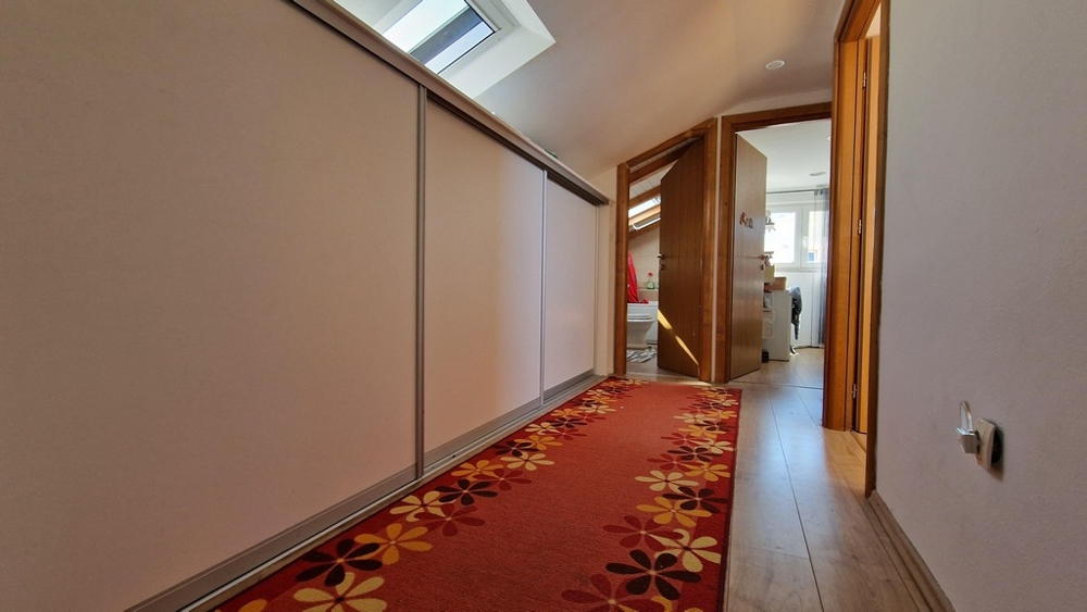 Chodba s červeným kobercom a skriňami pod strechou