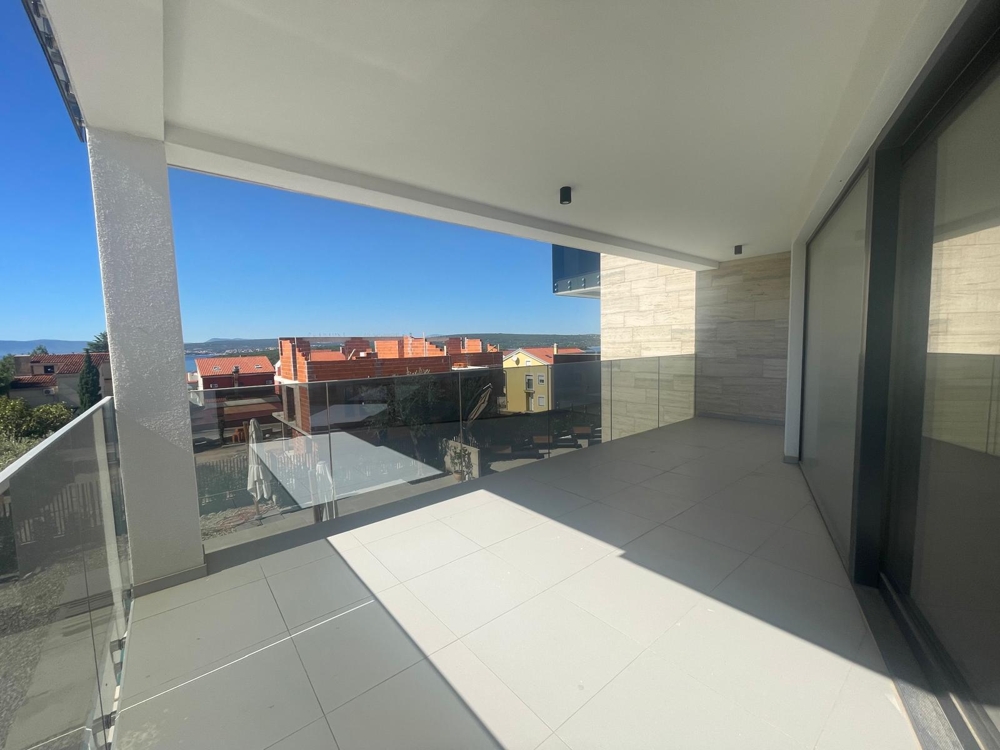 Veľká terasa s veľkými presklenými dverami a výhľadom na more, dláždená podlaha, čiastočne dokončený stav