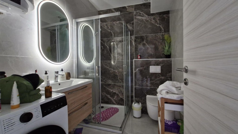 Kúpeľňa so sprchovým kútom, umývadlom a práčkou