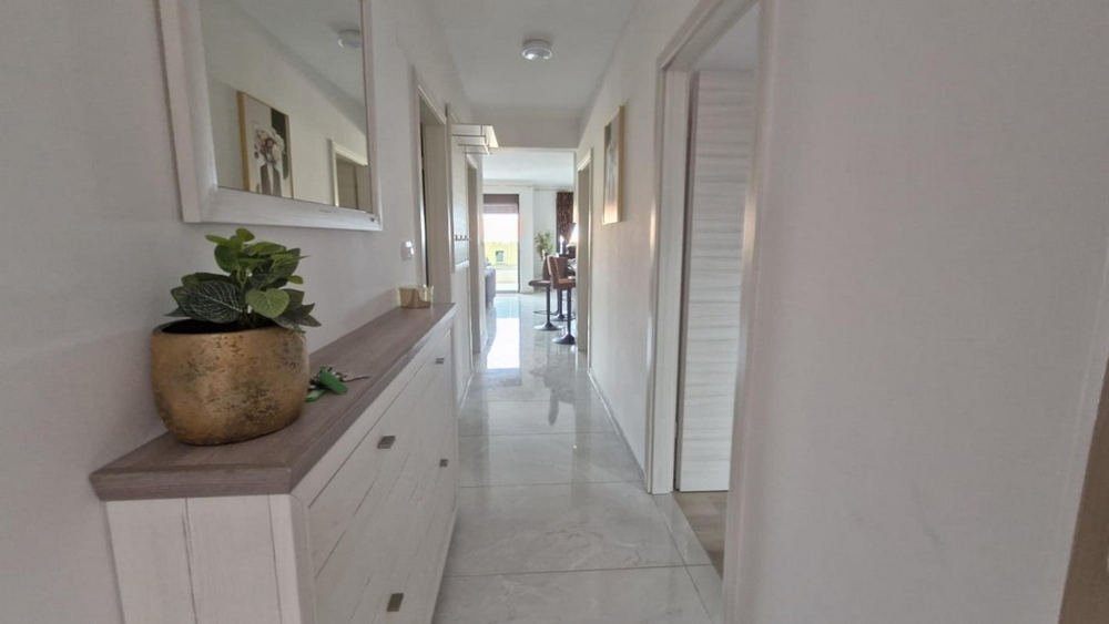 Predsieň bytu s komodou, zrkadlom a rastlinami