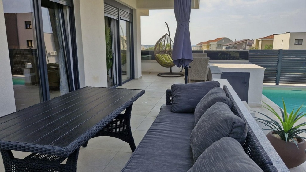 Zariadená záhrada a bazén rekreačného apartmánu A3413, ktorý je na predaj v Chorvátsku v Novalji.