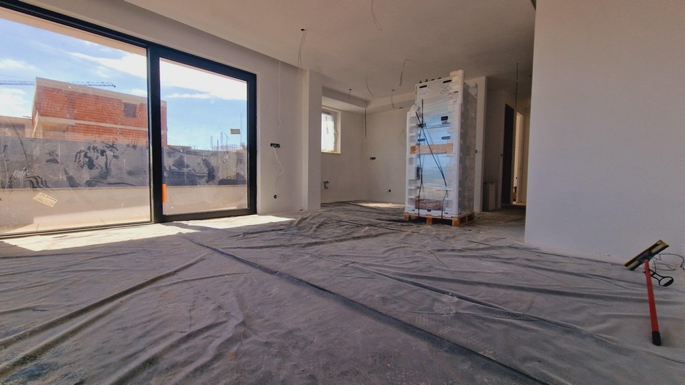 Vnútorný pohľad na nový byt s veľkými oknami a voľným výhľadom na terasu a okolie.