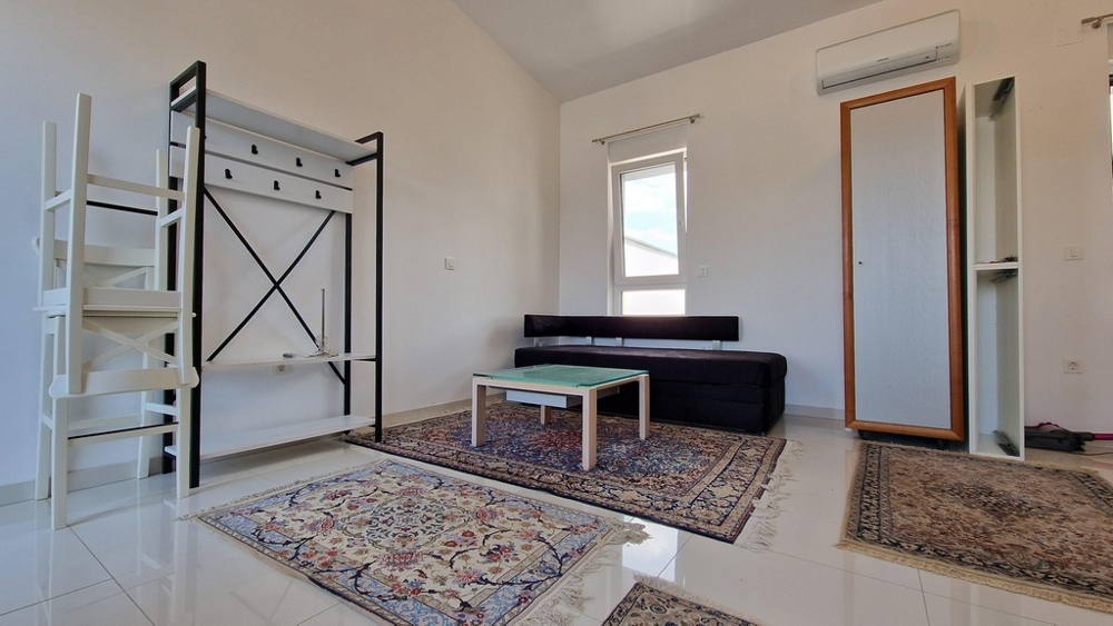 Obývacia izba s pohovkou, kobercami a klimatizáciou, moderný a svetlý štýl.