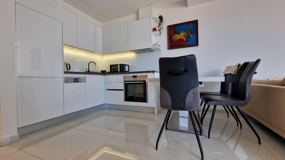 Priestranná, otvorená kuchyňa s jedálenským kútom a moderným vybavením vrátane vstavaných spotrebičov.