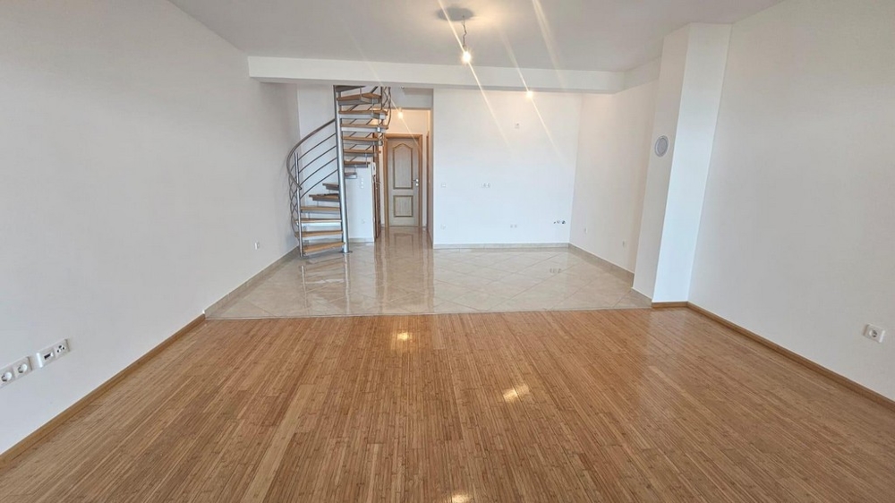 Veľká obývacia izba s točitým schodiskom a dláždenou časťou