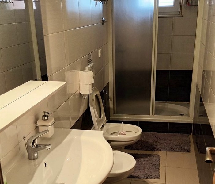 Kúpeľňa so sprchou, WC, bidetom a umývadlom, moderná dlažba.