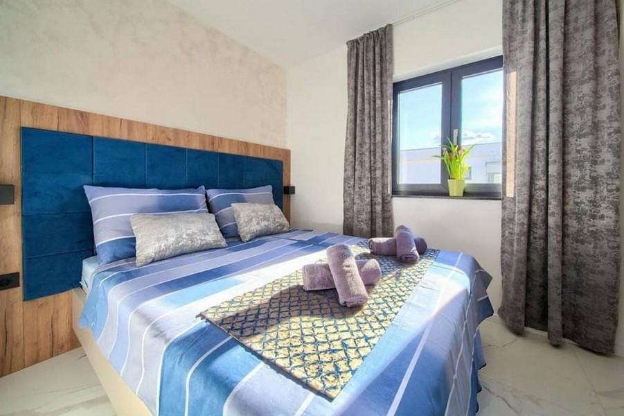 Moderná spálňa s veľkou posteľou a oknami