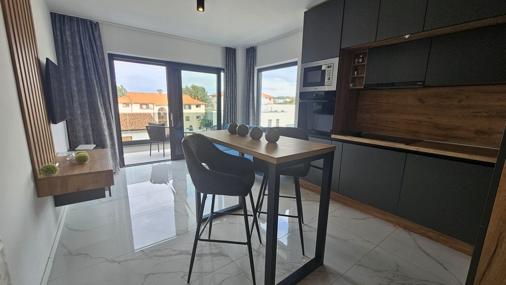 Otvorená kuchyňa a jedálenský kút s balkónom a veľkým oknom