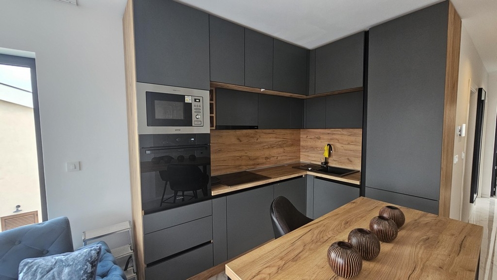 Moderná kuchynská linka so vstavanými spotrebičmi a jedálenským stolom