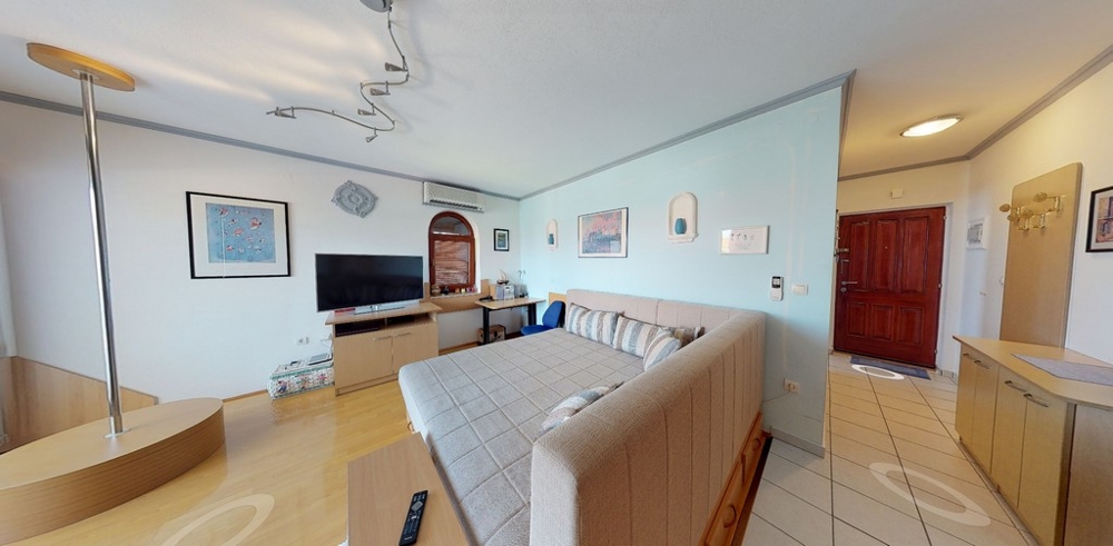 Obývacia izba s pohodlným gaučom a TV.