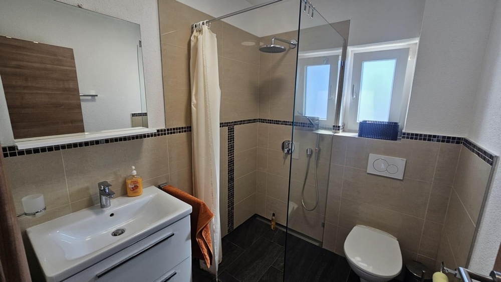 Moderná kúpeľňa so sprchovacím kútom.