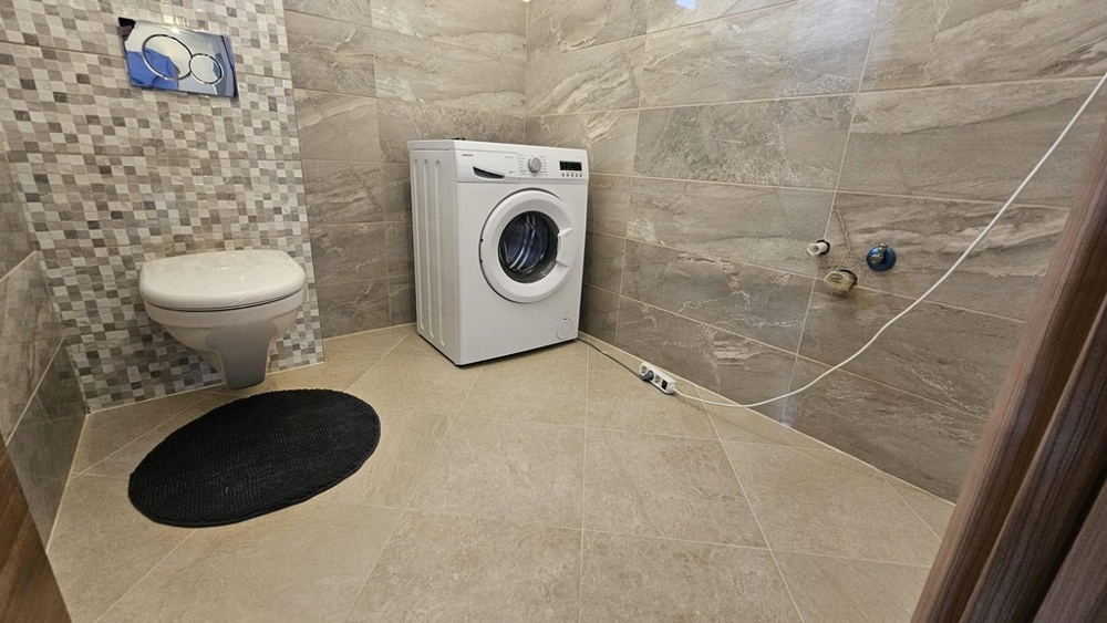Kúpeľňa s práčkou, WC a obklady stien.