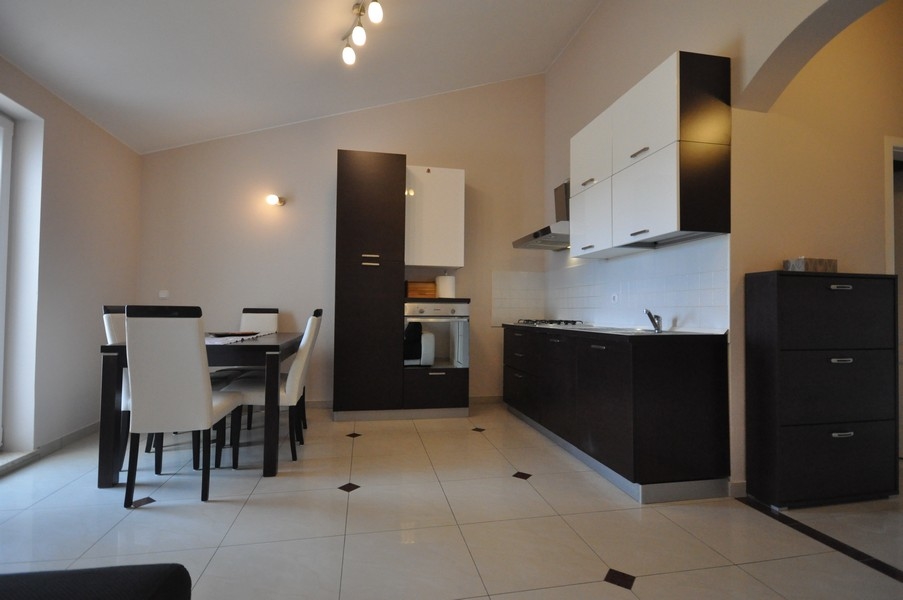 Pohľad na jedálenskú časť a funkčnú kuchyňu podkrovného bytu A3478 pri Poreči.