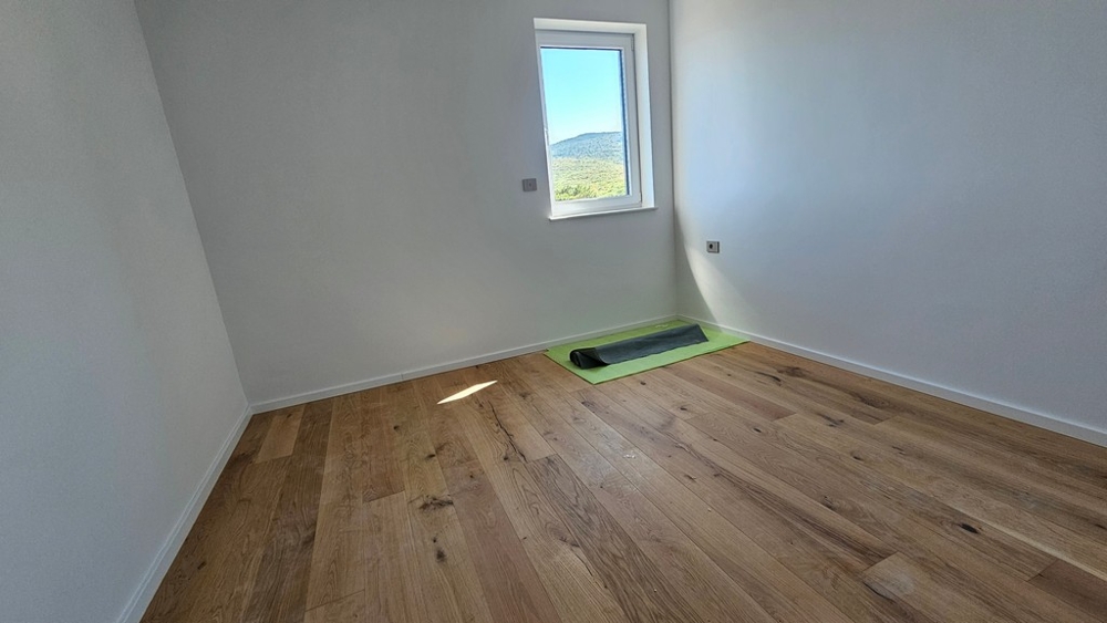 Spálňa s dubovým parketom a oknom s výhľadom na more, byt v novostavbe A3480