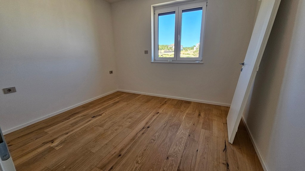 Spálňa s dubovými parketami a oknom v apartmáne A3481 vo Vrbniku