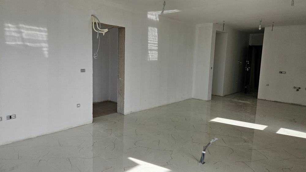 Nedokončená izba so svetlou dlažbou, pripravená na ďalšie vnútorné práce