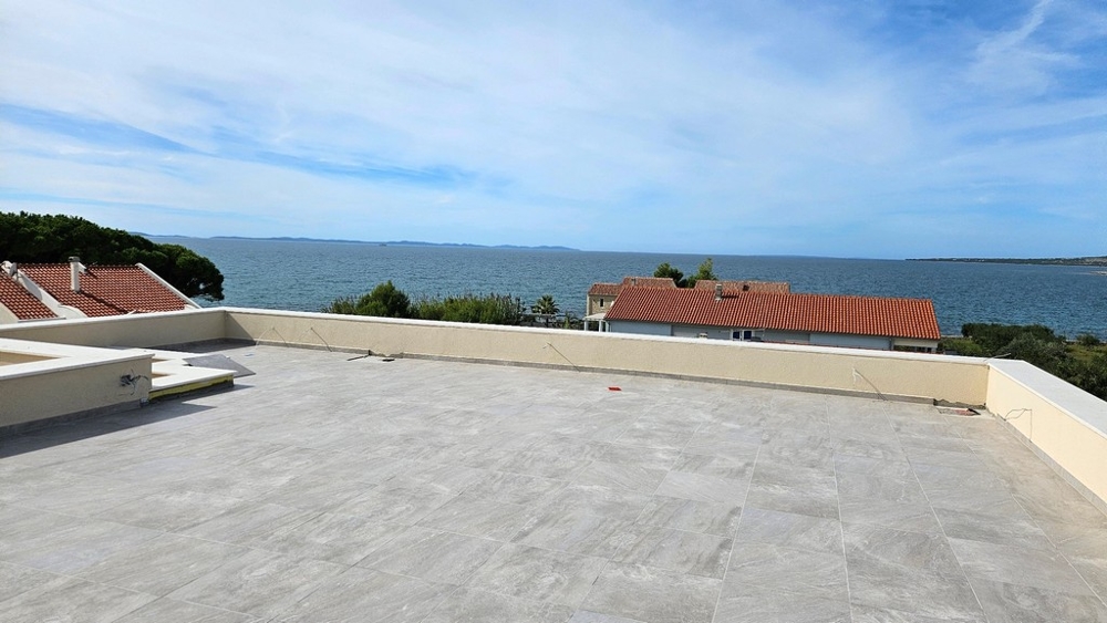 Strešná terasa s panoramatickým výhľadom na more a červené strechy domov pod ním