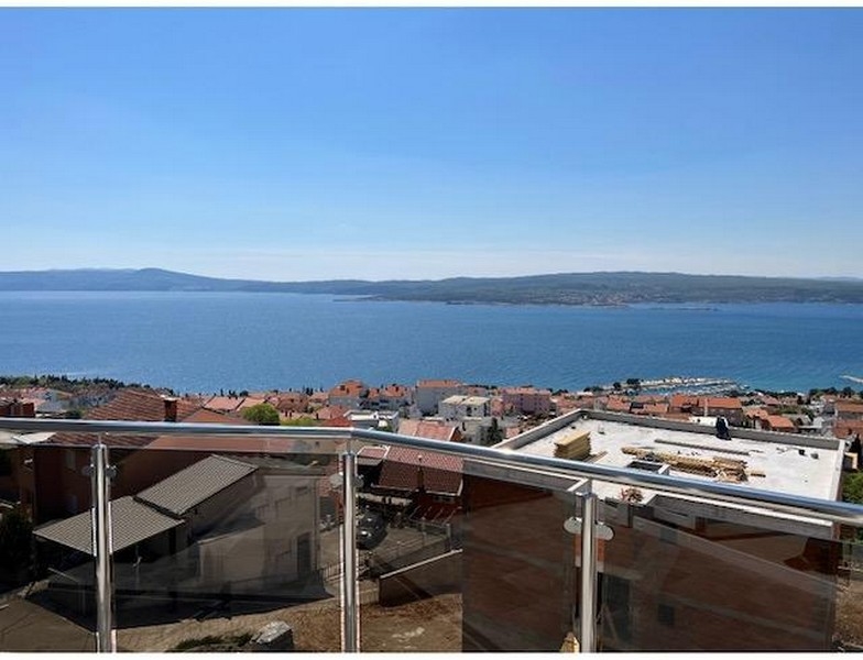 Terasa so skleneným zábradlím a panoramatickým výhľadom na more a mesto.