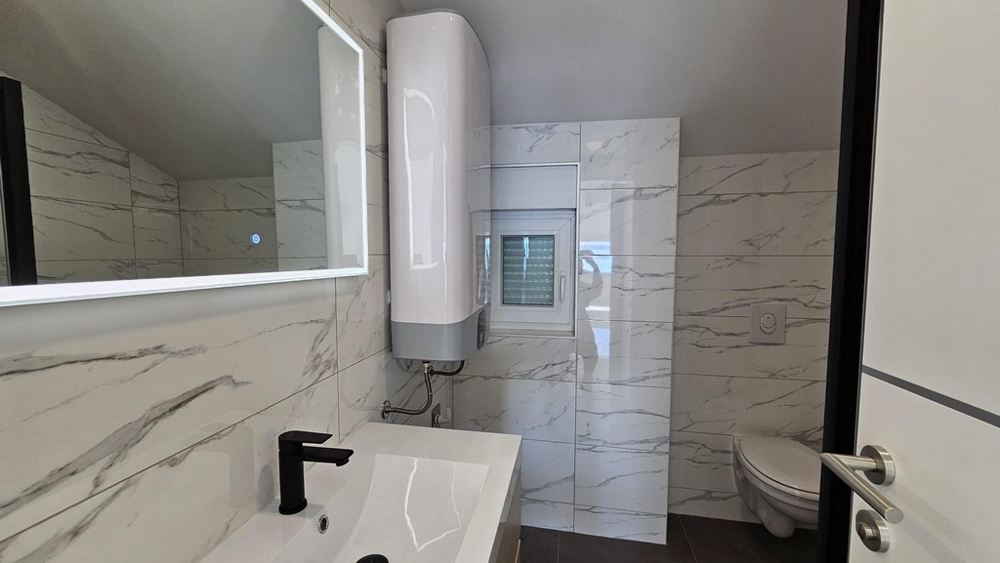 Kúpeľňa so zrkadlom, umývadlom a toaletou