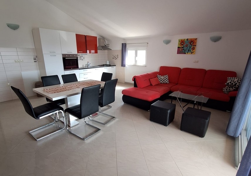 Jedálenský kút s kuchyňou a výhľadom na gauč v apartmáne.