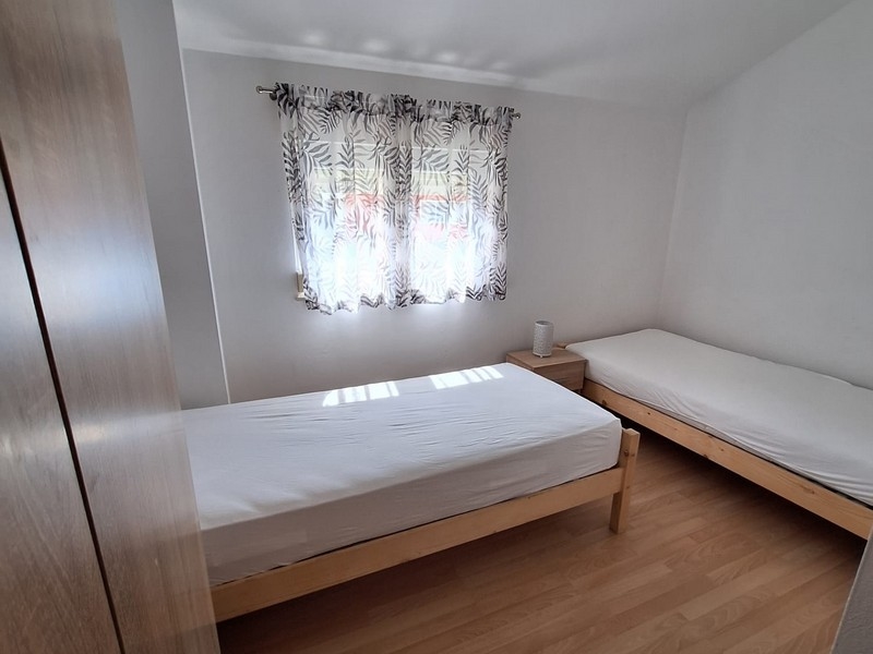 Spálňa s dvoma jednolôžkami a svetelnými závesmi