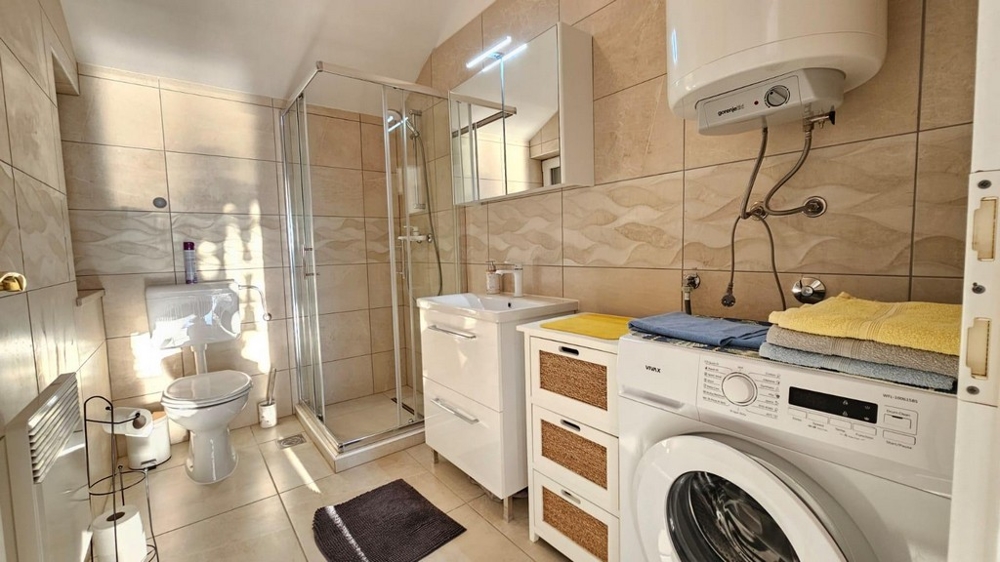 Dobre udržiavaná kúpeľňa so sprchovacím kútom.