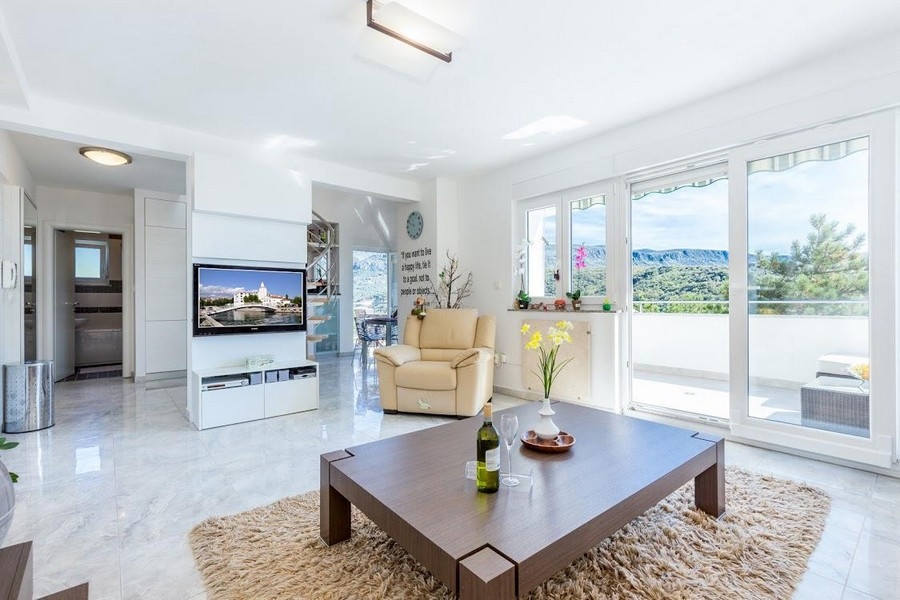 Obývacia izba s veľkým oknom a moderným zariadením