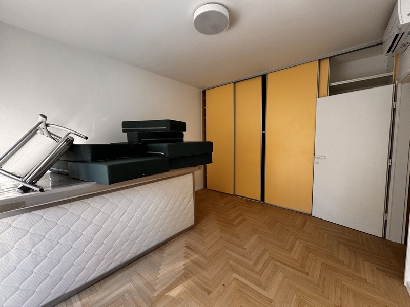 Izba so žltými dverami od skríň, naskladanými matracmi a klimatizáciou