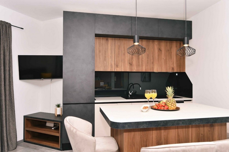 Štýlová kuchyňa s drevenými čelami, moderným dizajnom a priestrannou pracovnou plochou.