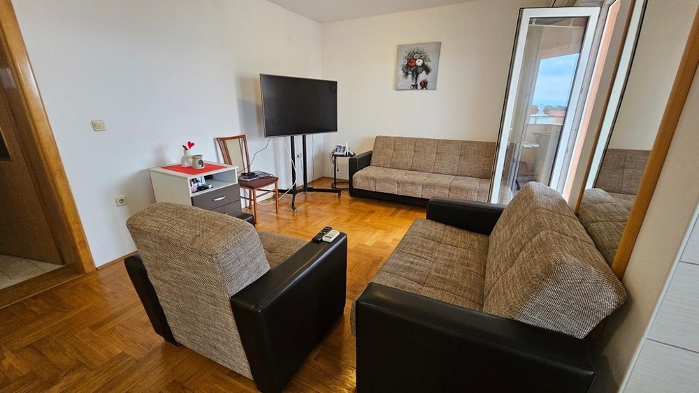 Zariadený obývací priestor s prístupom na terasu bytu na predaj v Malinskej (Chorvátsko).