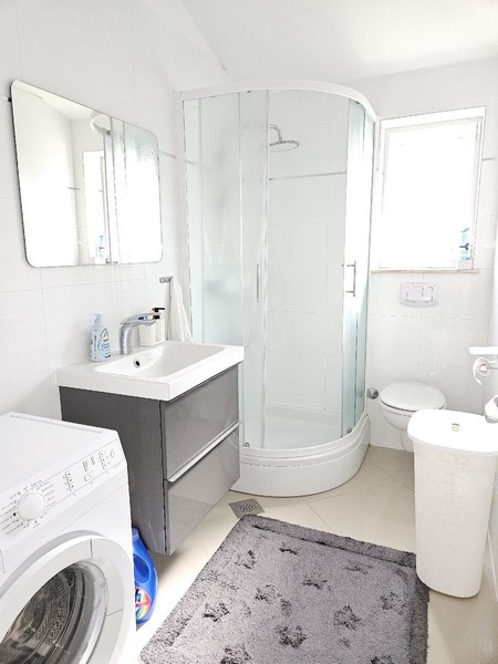 Svetlá kúpeľňa so sprchovacím kútom.