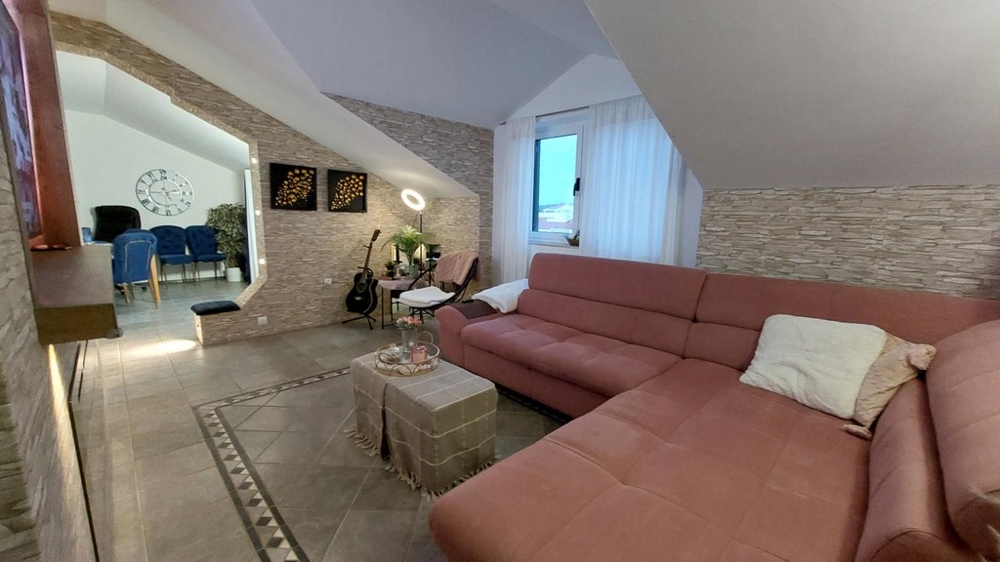 Priestranná obývacia izba s pohovkou a výhľadom na jedálenský stôl.