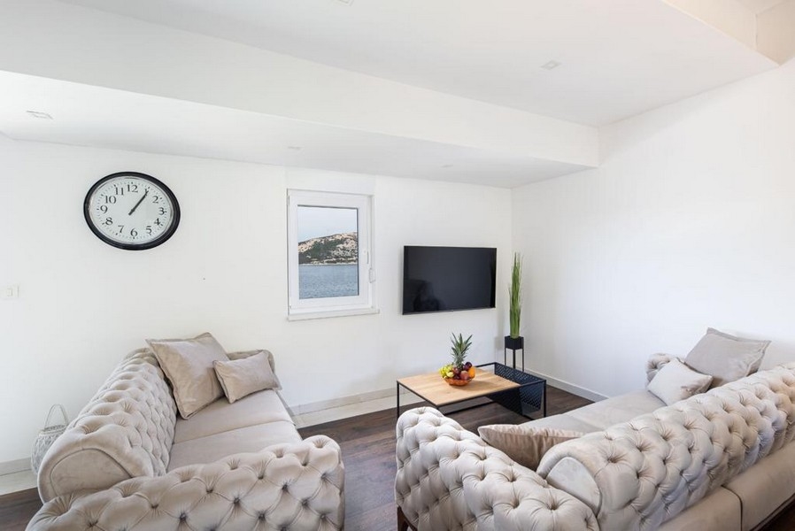 Obývacia izba s výhľadom na more a TV.