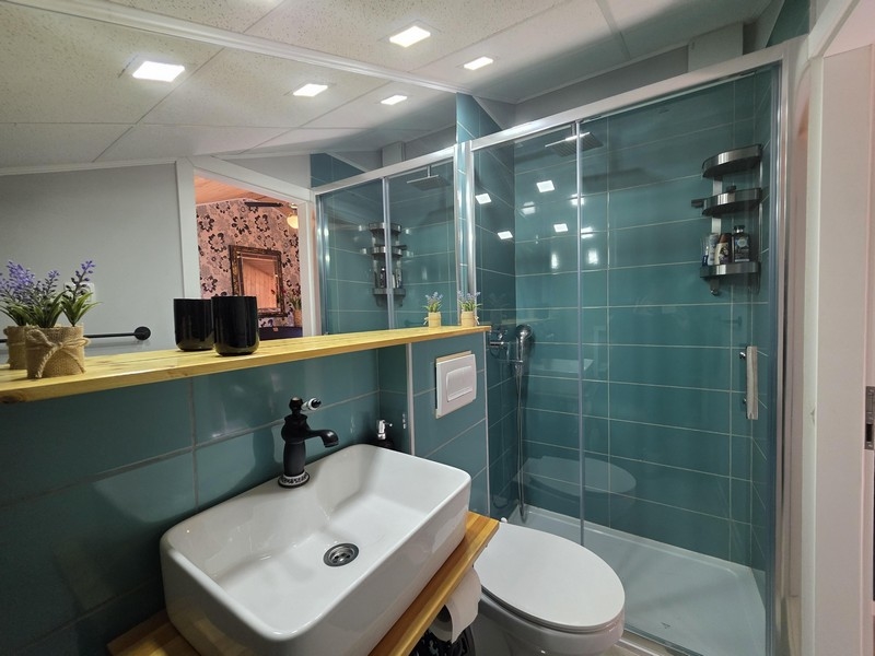 Moderná kúpeľňa so sprchovacím kútom a umývadlom