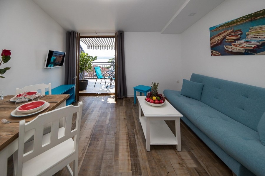 Obývacia izba s prístupom na balkón a výhľadom na more