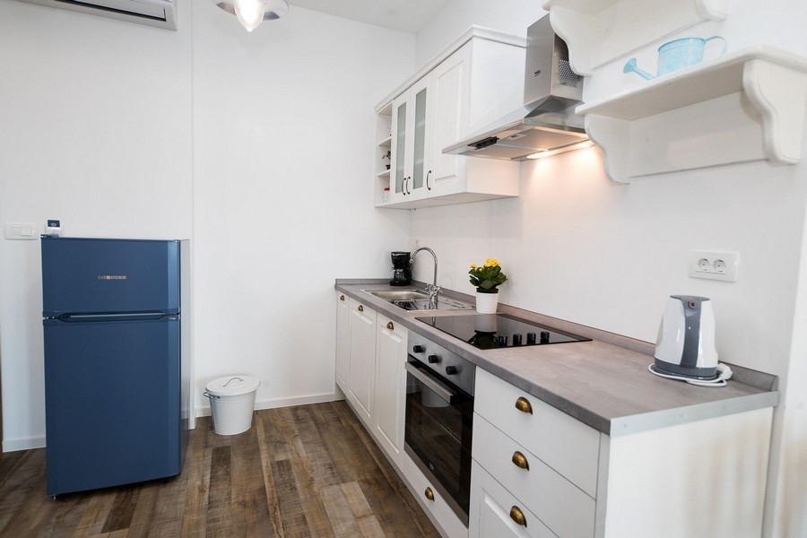 Kuchyňa s modrými prvkami a podlahami z tvrdého dreva