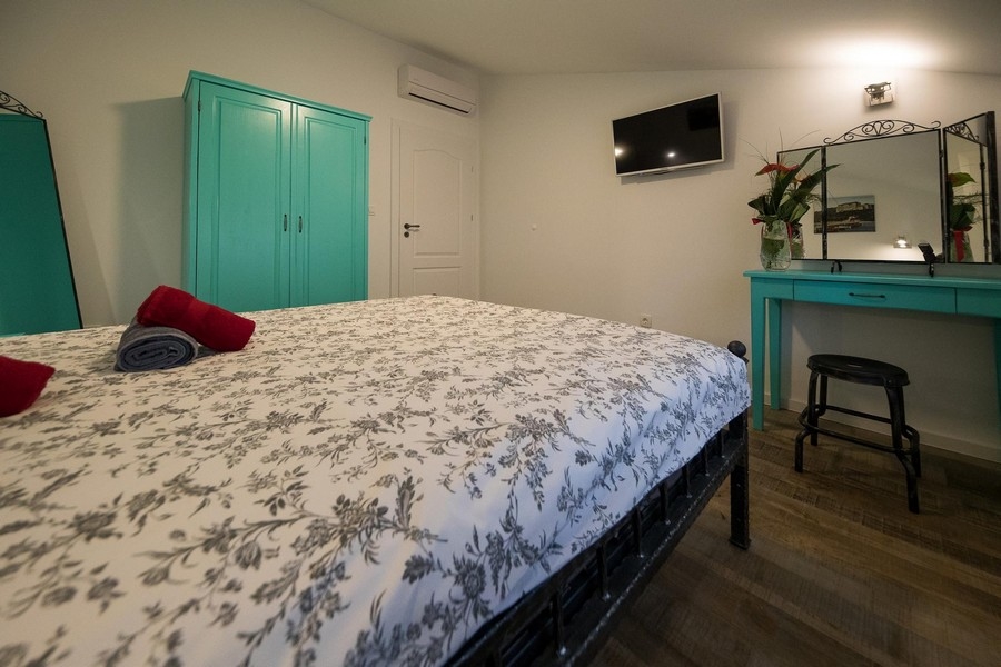 Spálňa s manželskou posteľou a nástenným zrkadlom