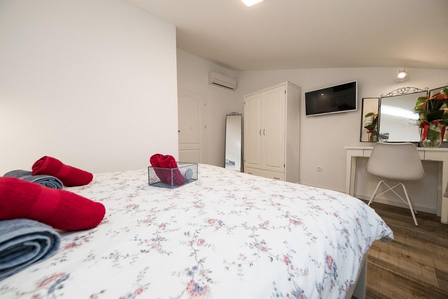 Spálňa s manželskou posteľou a TV