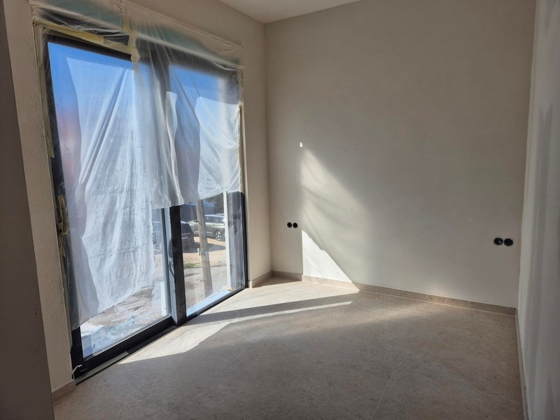 Slnkom presvetlená izba s oknom od podlahy až po strop