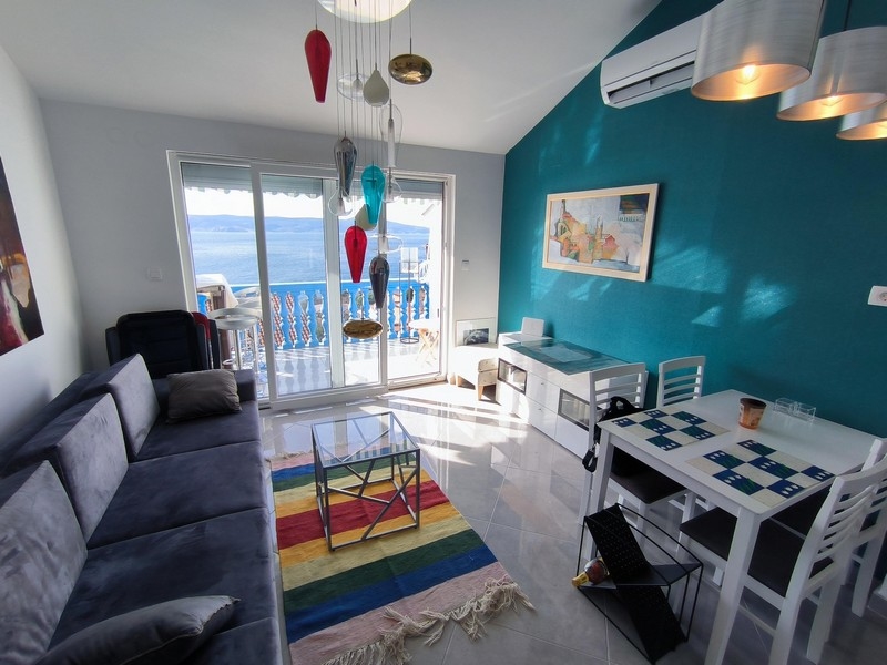 Obývacia izba s farebným osvetlením a výhľadom na more