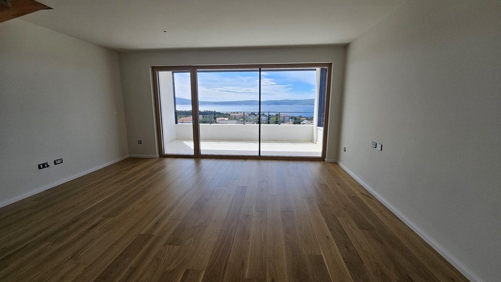 Obývacia izba s parketovou podlahou a veľkým oknom