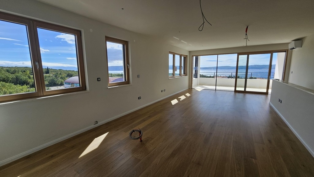 Priestranný obývací priestor s výhľadom na more a oknami od podlahy až po strop