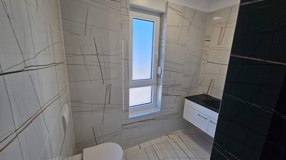 Kúpeľňa s moderným obkladom a oknom