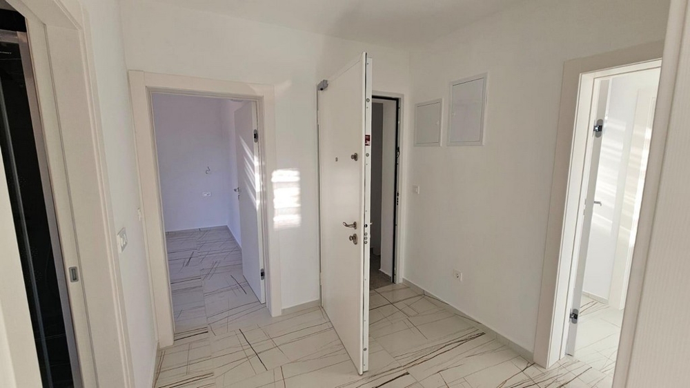 Predsieň s bielymi vstupnými dverami a vstupom do ďalších miestností